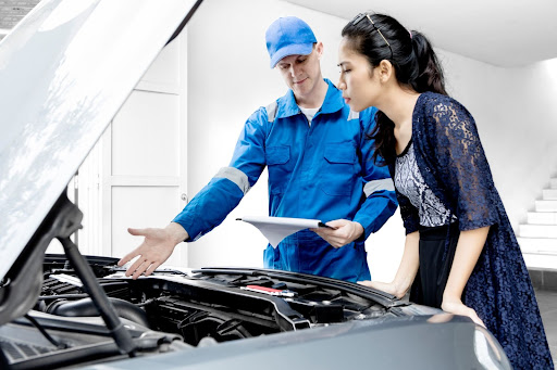 mechanic discussing the cost of an oil change and the benefits of oil changes with customer