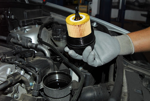 auto mechanic holding oil filter