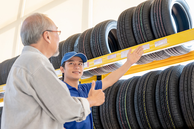 auto mechanic showing a customer some car tire options