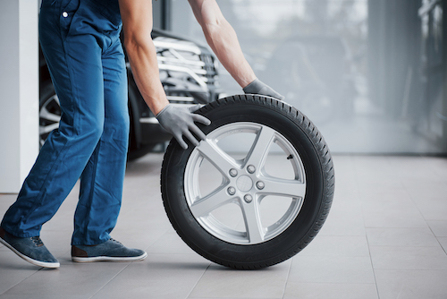 mechanic-holding-a-tire-tire-at-the-repair-garage