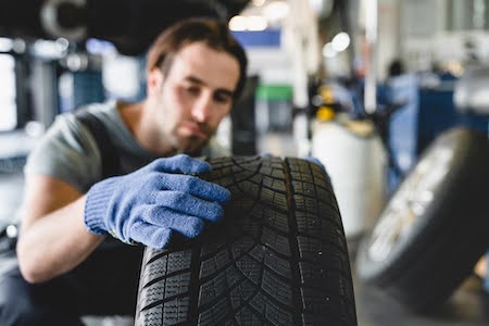 Man checking tire treads